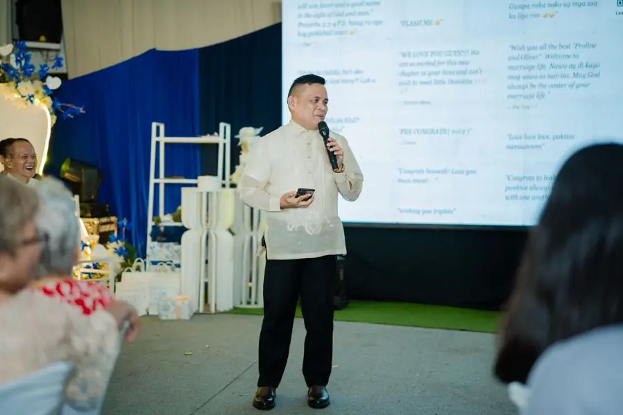 A guest giving a speech in front of the well wishes wall