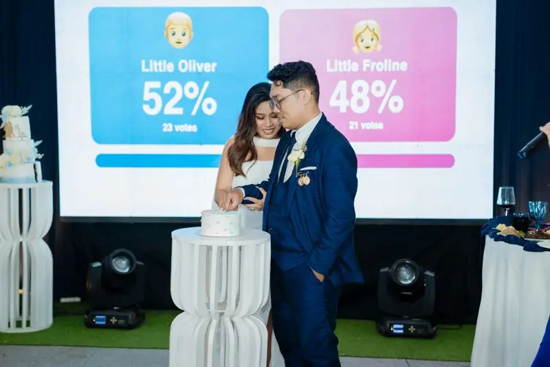 The couple cutting the cake under the live gender reveal vote